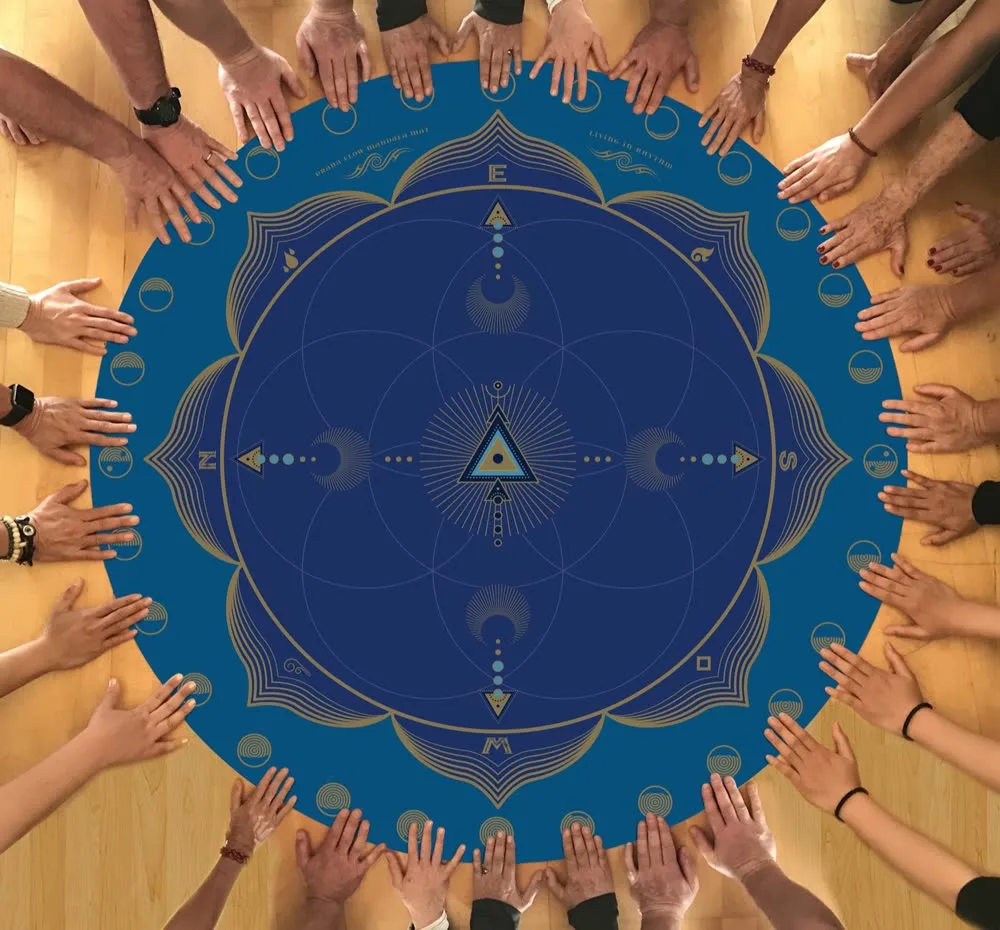 A circle of many hands resting on a deep-blue solar-lunar mandala