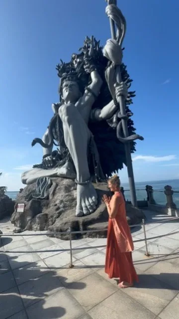 Prayer before a Shiva statue overlooking the sea, Kerala
